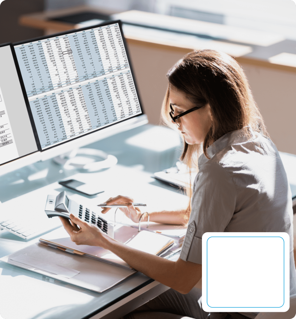 Woman working with calculator and computer spreadsheets.
