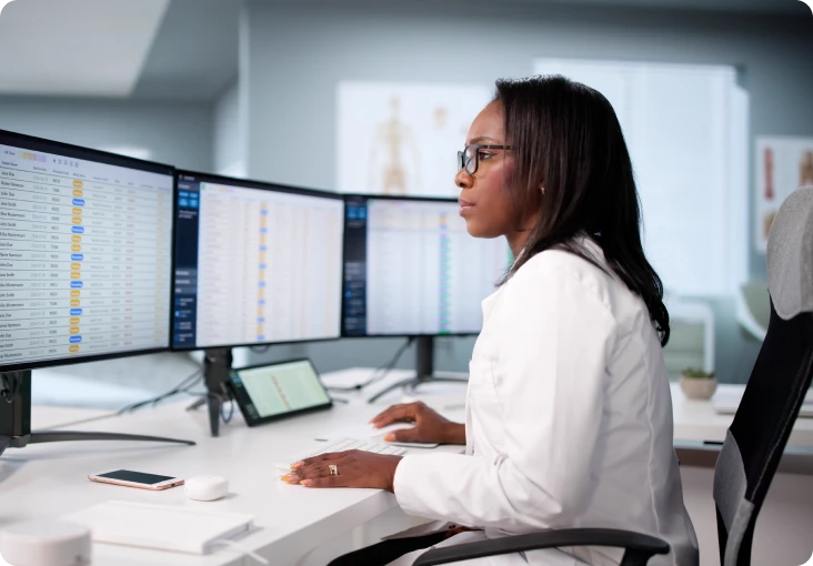Doctor analyzing data on multiple monitors.